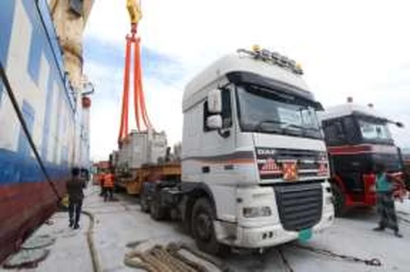 Truck handling project cargo beside a vessel
